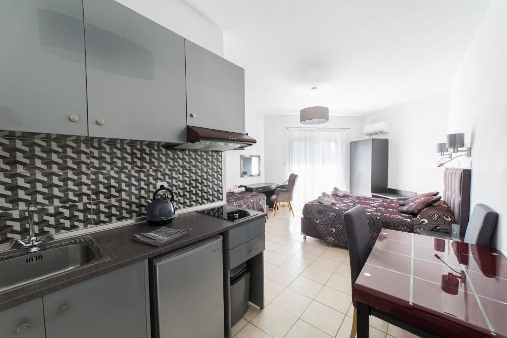 eine Küche und ein Wohnzimmer mit einem Waschbecken und einem Sofa in der Unterkunft Anelia Boutique Studios & Apartments in Faliraki