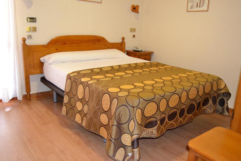 een slaapkamer met een groot bed met een bruine sprei bij San Marcos in Huesca