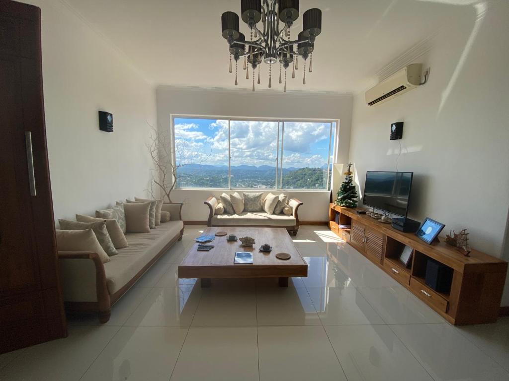 uma sala de estar com um sofá e uma mesa em The Heaven's Villa Kandy em Kandy