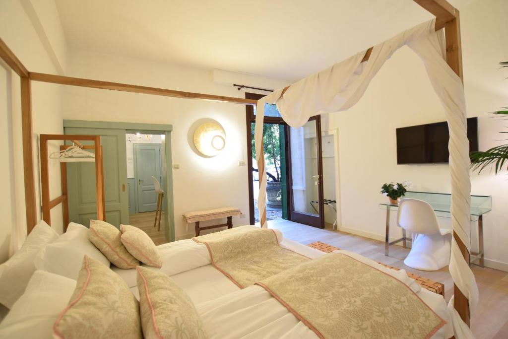 een slaapkamer met een wit bed en een televisie bij Isola Memmia in Padua