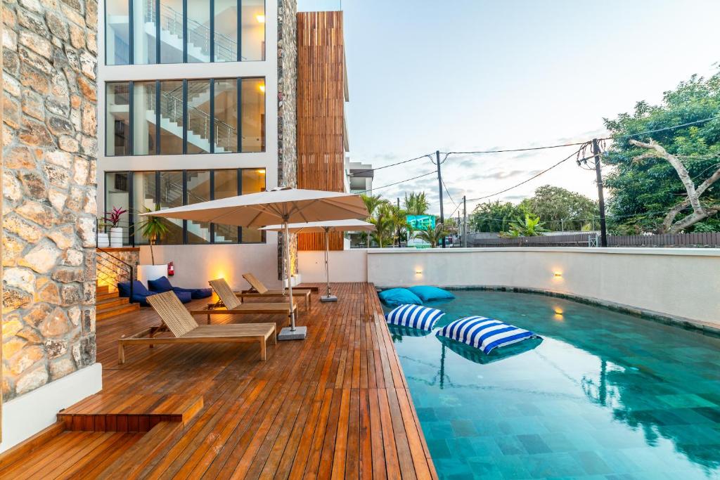 een zwembad met ligstoelen en een parasol bij One Bay Residence-Apartment 9-Brand New Apartment in Grand Baie