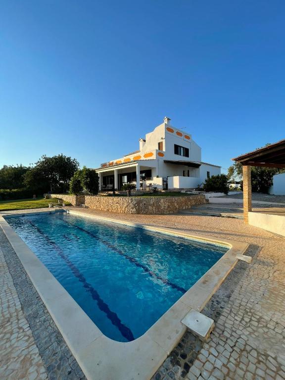 a swimming pool in front of a house at Casa Esperança - carefree living with big private pool and great views in Olhão