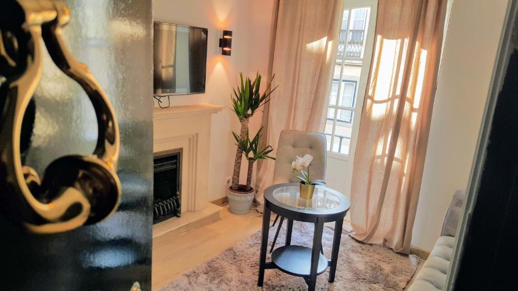 una sala de estar con una mesa y una chimenea en Olival Home- Feels like home, en Lisboa