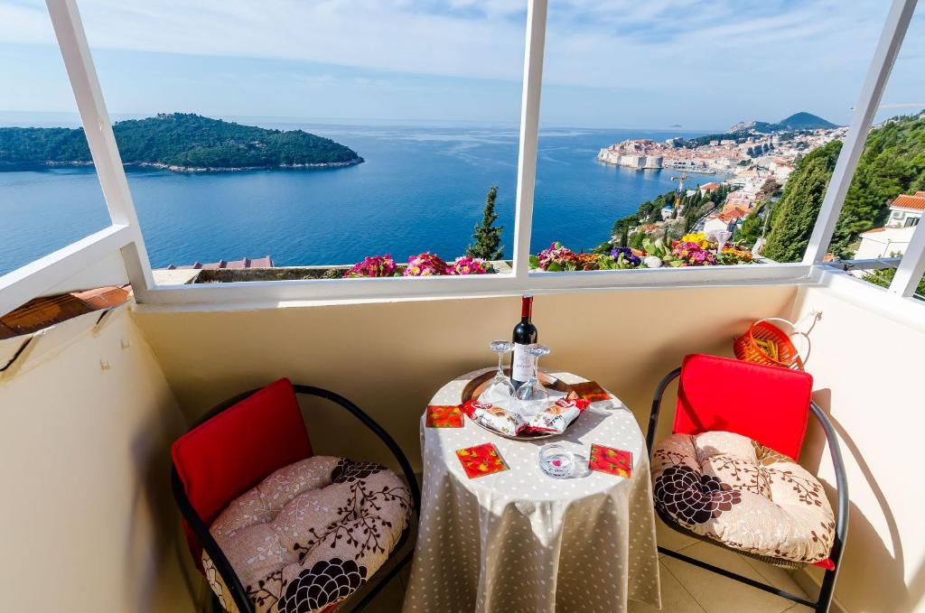 una mesa y sillas en un balcón con vistas al océano en Apartment Vedrana, en Dubrovnik