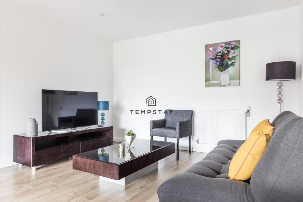 a living room with a couch and a table at Modern Private Apartment -Balcony-Tube Station in London