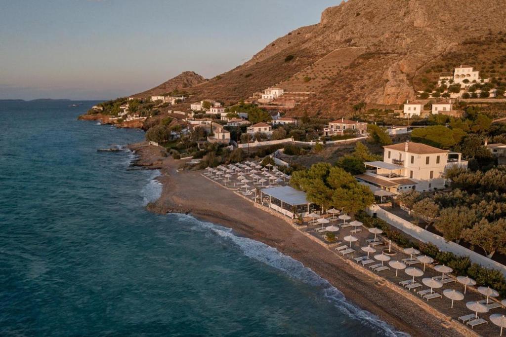 eine Luftansicht auf einen Strand mit Sonnenschirmen und dem Meer in der Unterkunft Hydra Erato in Hydra