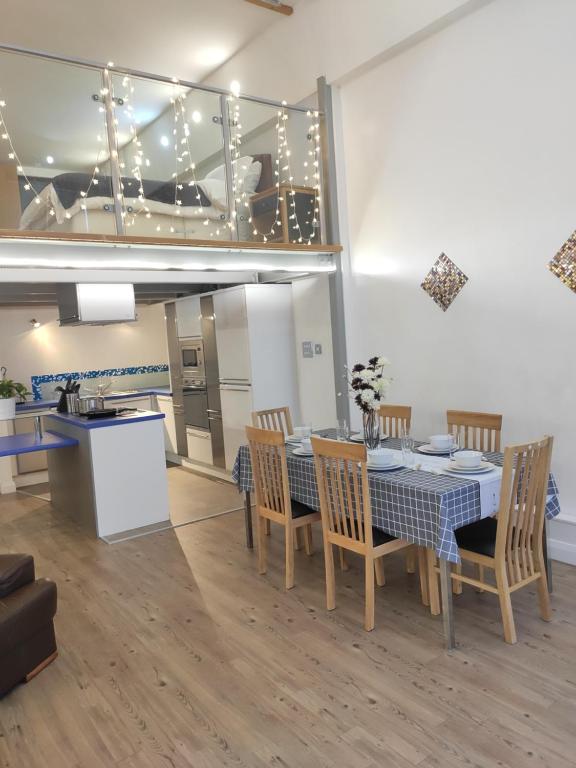 uma sala de jantar com mesa e cadeiras e uma cozinha em City Centre duplex 3rooms apartment with parking em Nottingham