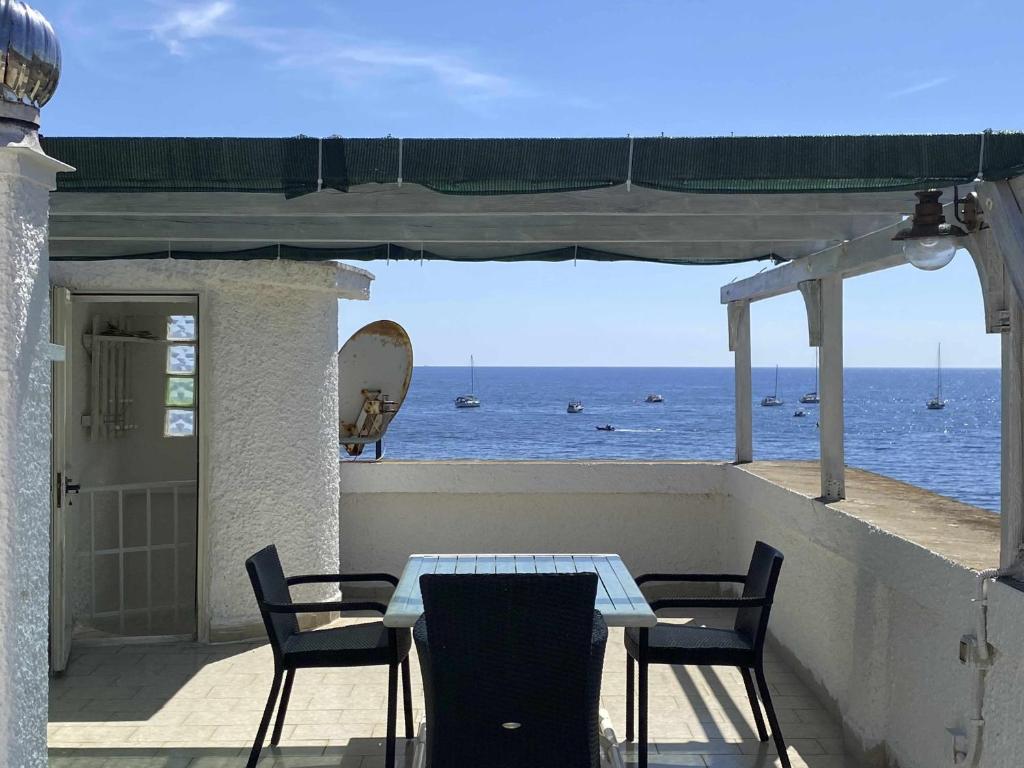 una mesa y sillas en un balcón con vistas al océano en Santa Marinella - La Terrazza sul Mare en Santa Marinella