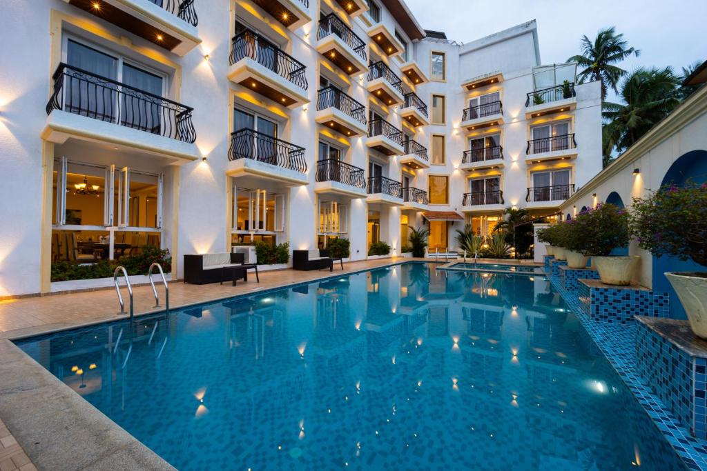 a swimming pool in front of a building at Alvorada Resort-3 Star Resort In Baga in Arpora