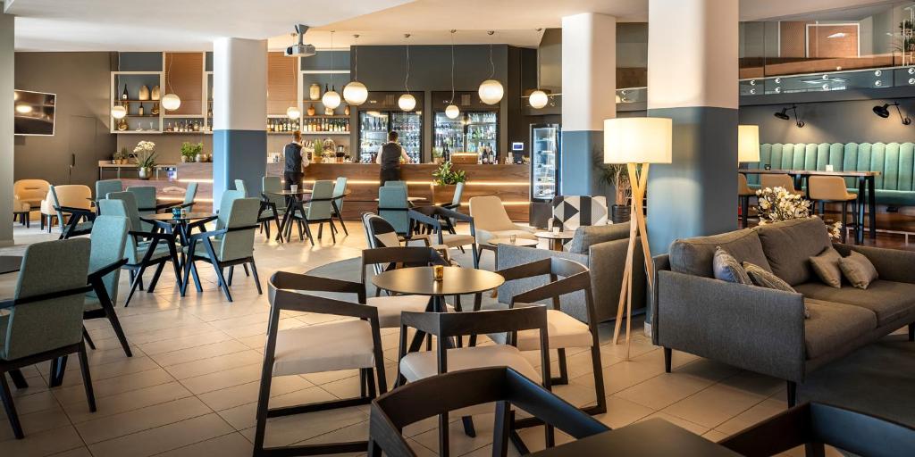 a restaurant with tables and chairs and a bar at Aminess Vival Maestral Hotel in Novigrad Istria