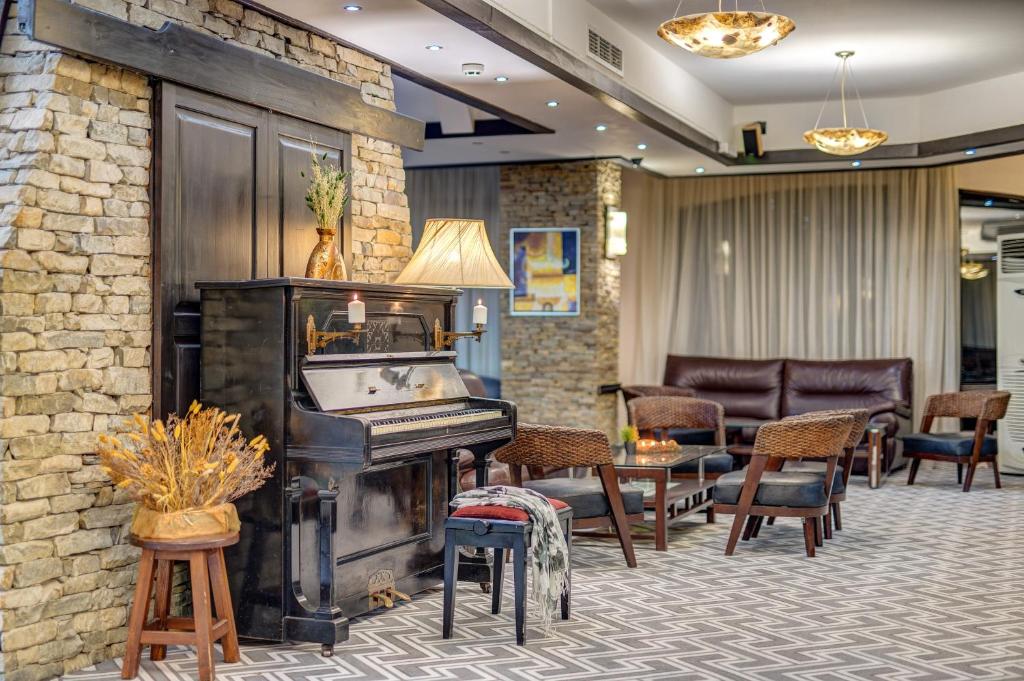 um átrio com piano, mesas e cadeiras em Hotel Bansko SPA & Holidays - Free Parking em Bansko