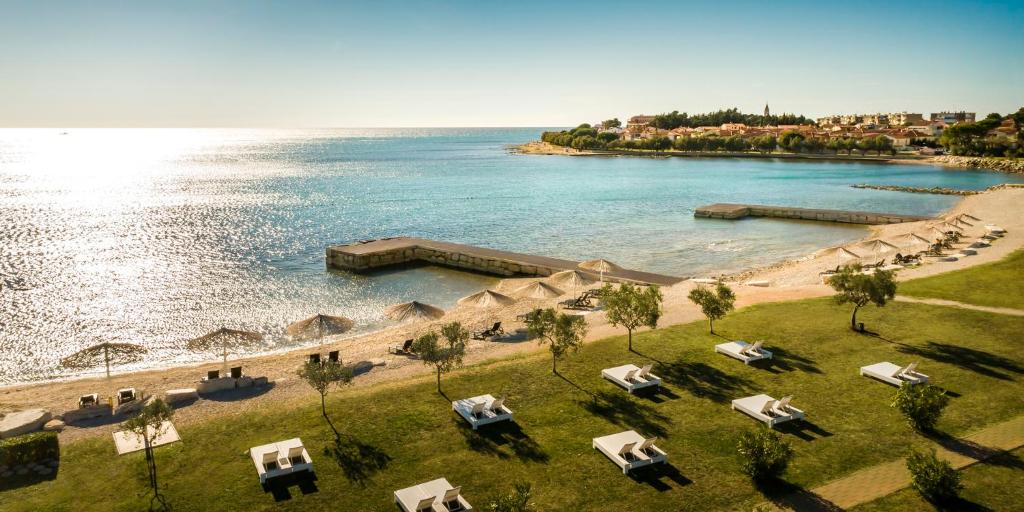 an aerial view of a beach with chairs and the water at Aminess Vival Maestral Hotel in Novigrad Istria