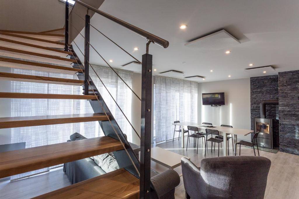 a staircase in a living room with a table and chairs at Ski Villa Rubicon in Loučná pod Klínovcem