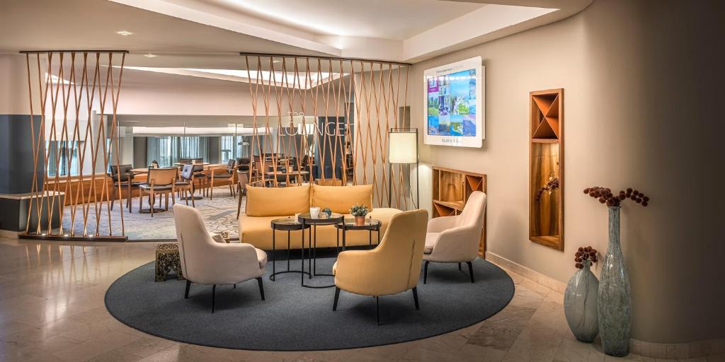 a lobby with a table and chairs and a dining room at Aminess Vival Maestral Hotel in Novigrad Istria