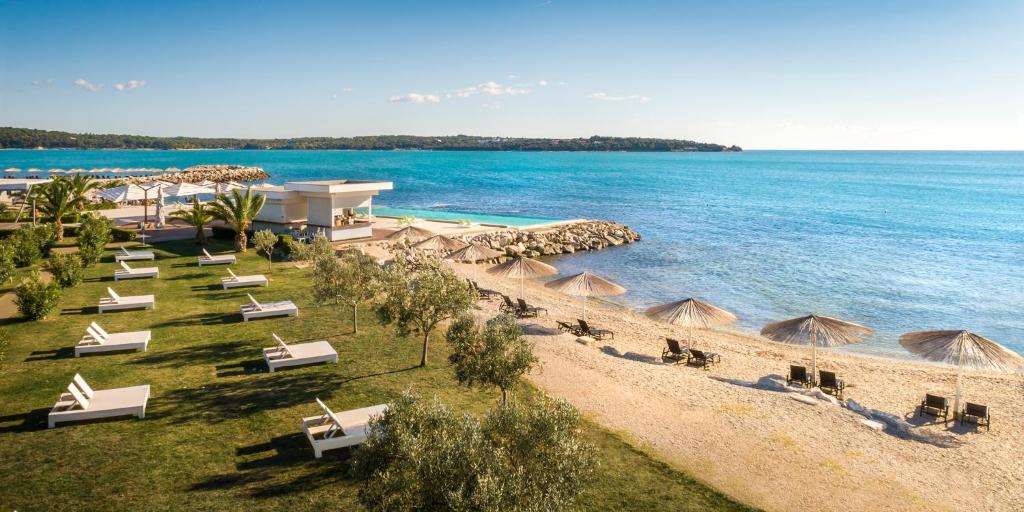 an aerial view of a beach with chairs and umbrellas at Aminess Vival Maestral Hotel in Novigrad Istria