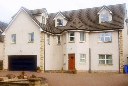 a large white house with a large garage at Meadowside B&B in Cupar