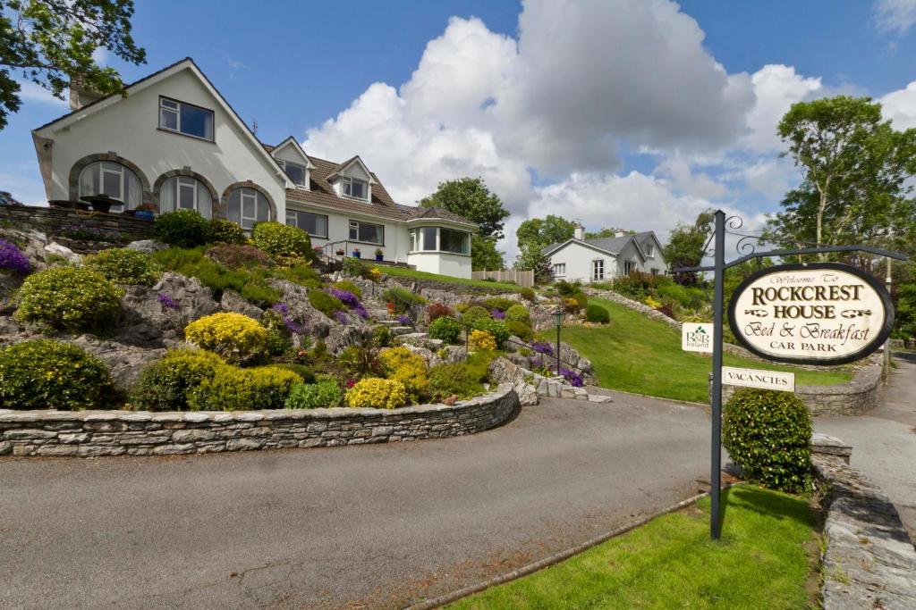 a sign in front of a house with a garden at Rockcrest House in Kenmare