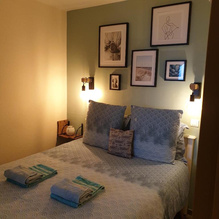 a bedroom with a bed with two pillows on it at Le charmant des Sables Blancs in Douarnenez