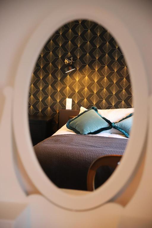 une chambre avec un lit avec un mur noir dans l'établissement Appart’Edith - Charmant appartement de tourisme, à La Neuville-aux-Larris