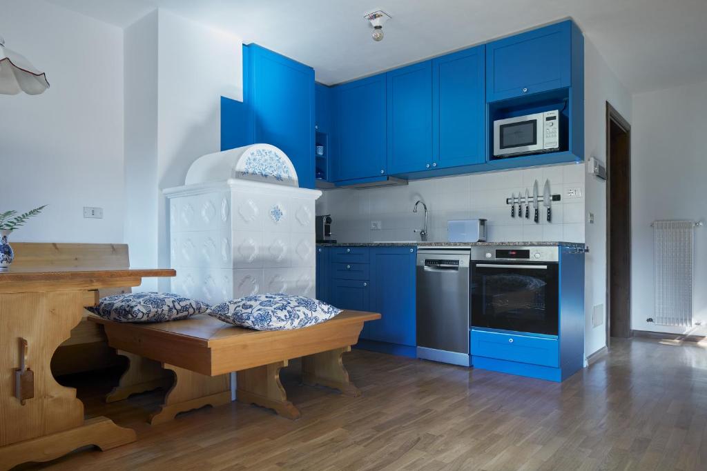 a kitchen with blue cabinets and a wooden table at Casa Sauris in Sauris
