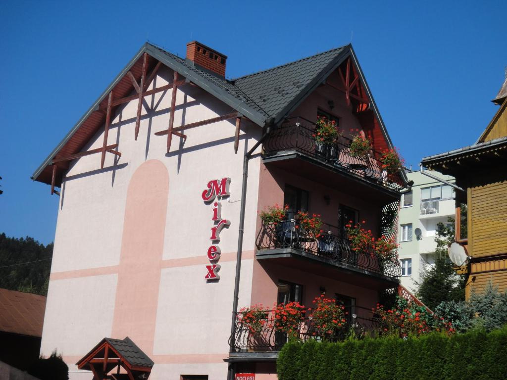 a building with flower boxes on the side of it at Mirex in Krynica Zdrój