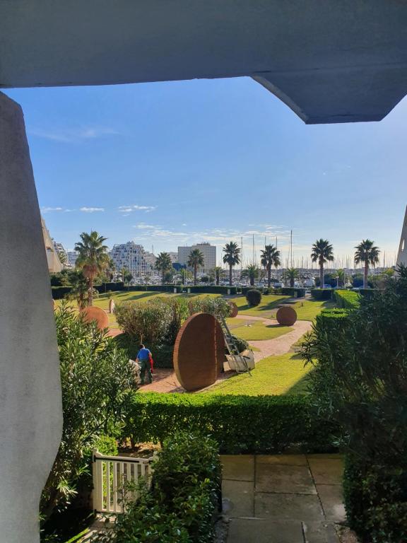 - une vue sur un parc avec une personne debout dans l'herbe dans l'établissement Joli studio, la grande pyramide, parking, à La Grande Motte