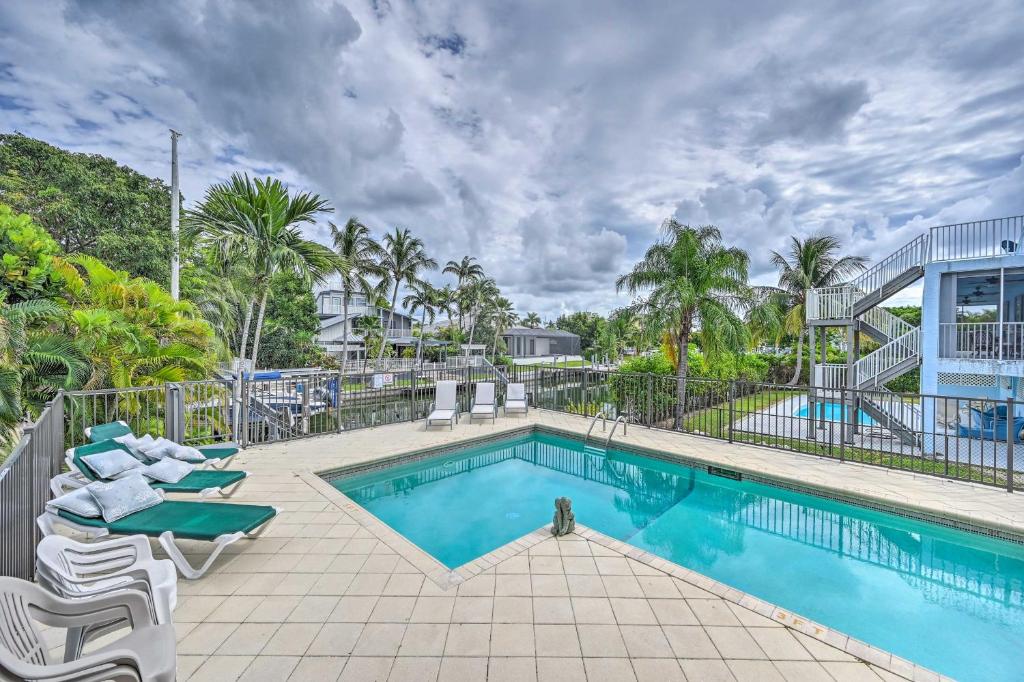 a swimming pool with lounge chairs next to a resort at Waterfront Marco Island House with Shared Dock! in Marco Island