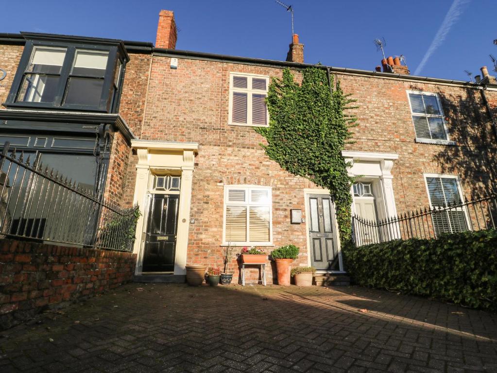 a red brick house with a brick driveway at Blacksmiths Retreat, 50 Holgate Road in York