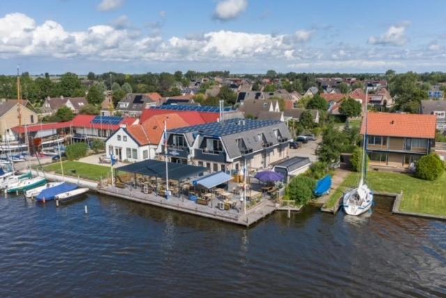 an aerial view of a large house on the water at Appartementen De Helling 44 in Heeg