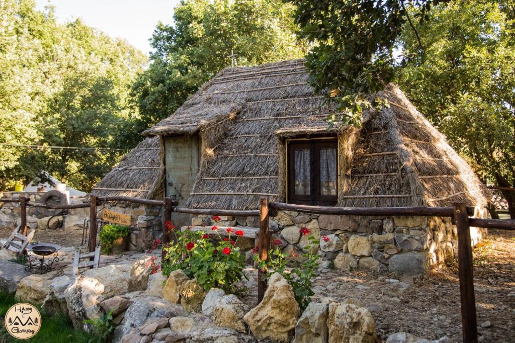stary kamienny dom z dachem krytym strzechą w obiekcie HAPPY GLAMPING MADONIE w mieście Polizzi Generosa