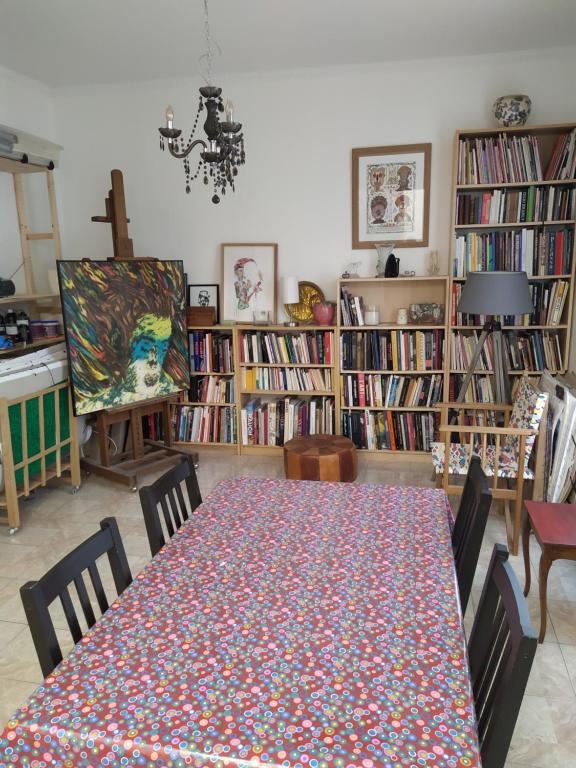 a dining room with a table with chairs and books at Appartement atelier d'artiste in Vanves