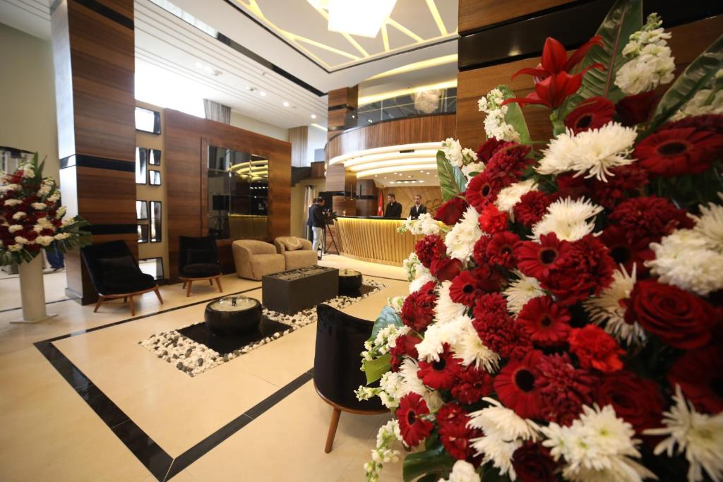 a large display of red and white flowers in a lobby at فندق صحارى الخليج Sahara Gulf Hotel Apartments in Amman