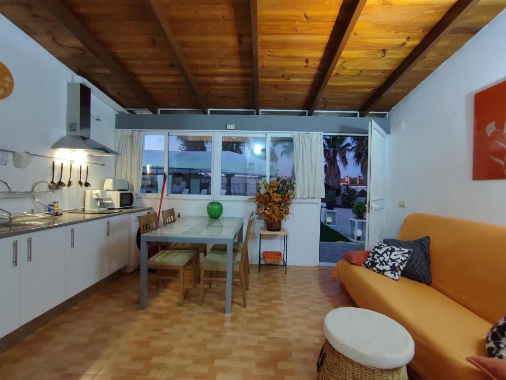 Il comprend une cuisine et un salon avec une table et un canapé. dans l'établissement Apartamento 1, Chalet Manzano a 15" de Sevilla, a 30" del Aeropuerto de Sevilla, à Villanueva del Ariscal