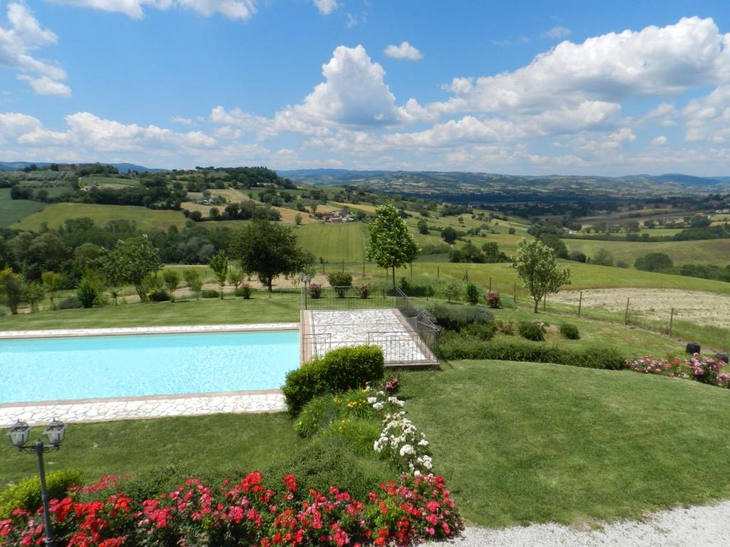 une image d'un jardin avec une piscine dans l'établissement La Campagna Di Assignano, à Collazzone