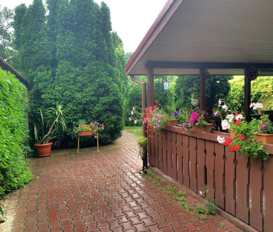 a brick walkway with a gazebo with flowers on it at Pensiunea Doria in Timişoara