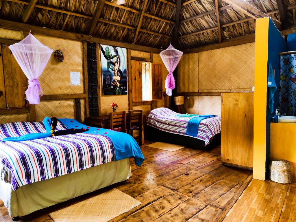 a bedroom with a bed, a chair, and a tv at Eco-Hotel Mayachik in San Juan La Laguna