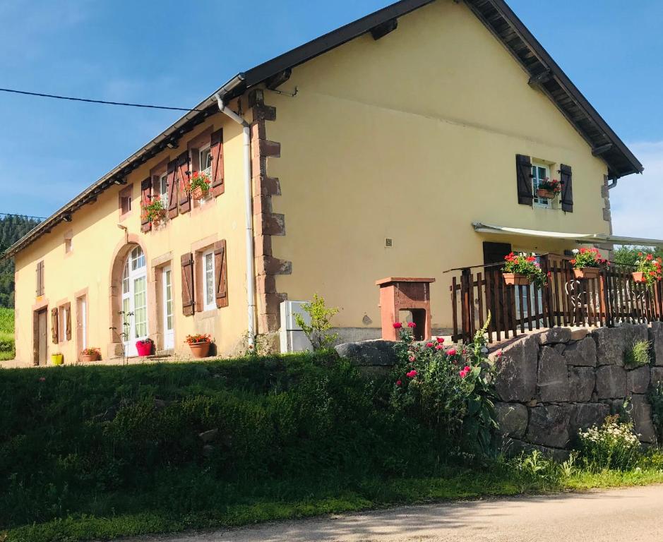een huis met bloemen ervoor bij Aux Trois Gîtes in La Chapelle