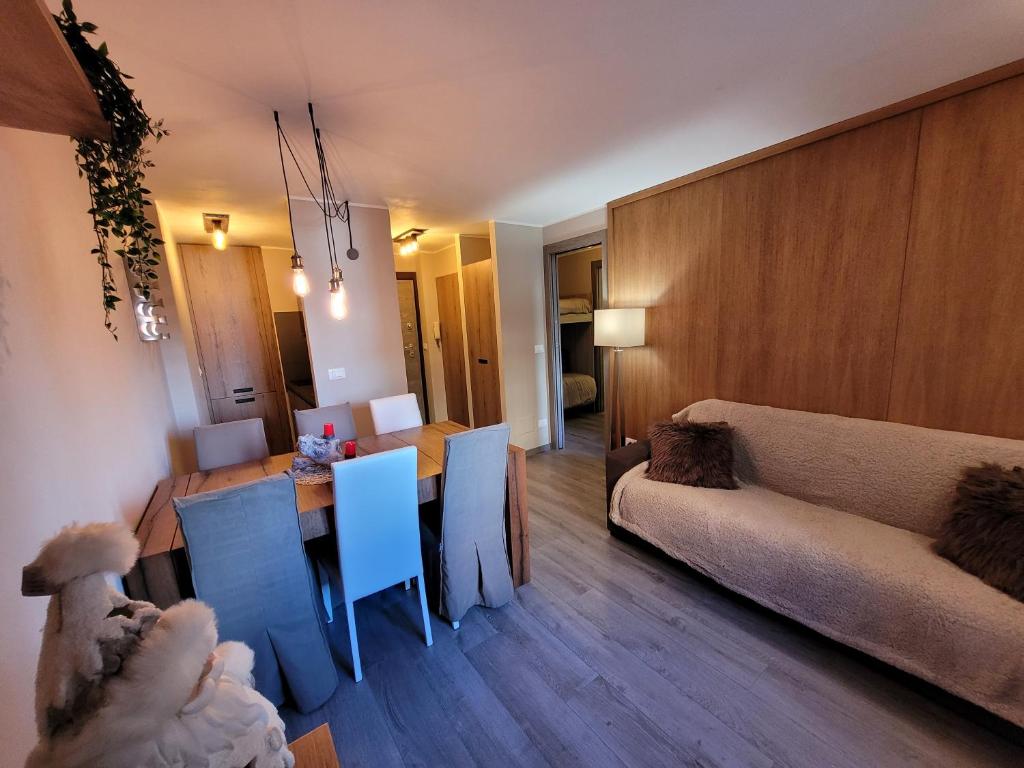 ein Wohnzimmer mit einem Sofa, einem Tisch und Stühlen in der Unterkunft SAUZE d'OULX LOVELY AND SUPER CENTRAL in Sauze dʼOulx