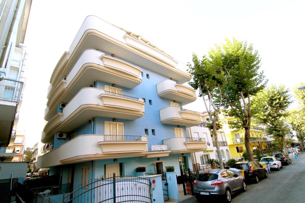 um edifício azul com varandas numa rua da cidade em Residence Blu Marine em Rimini