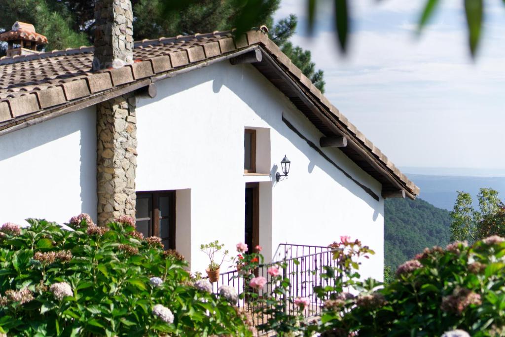 a white house with flowers in front of it at Casas Arbillas in Arenas de San Pedro