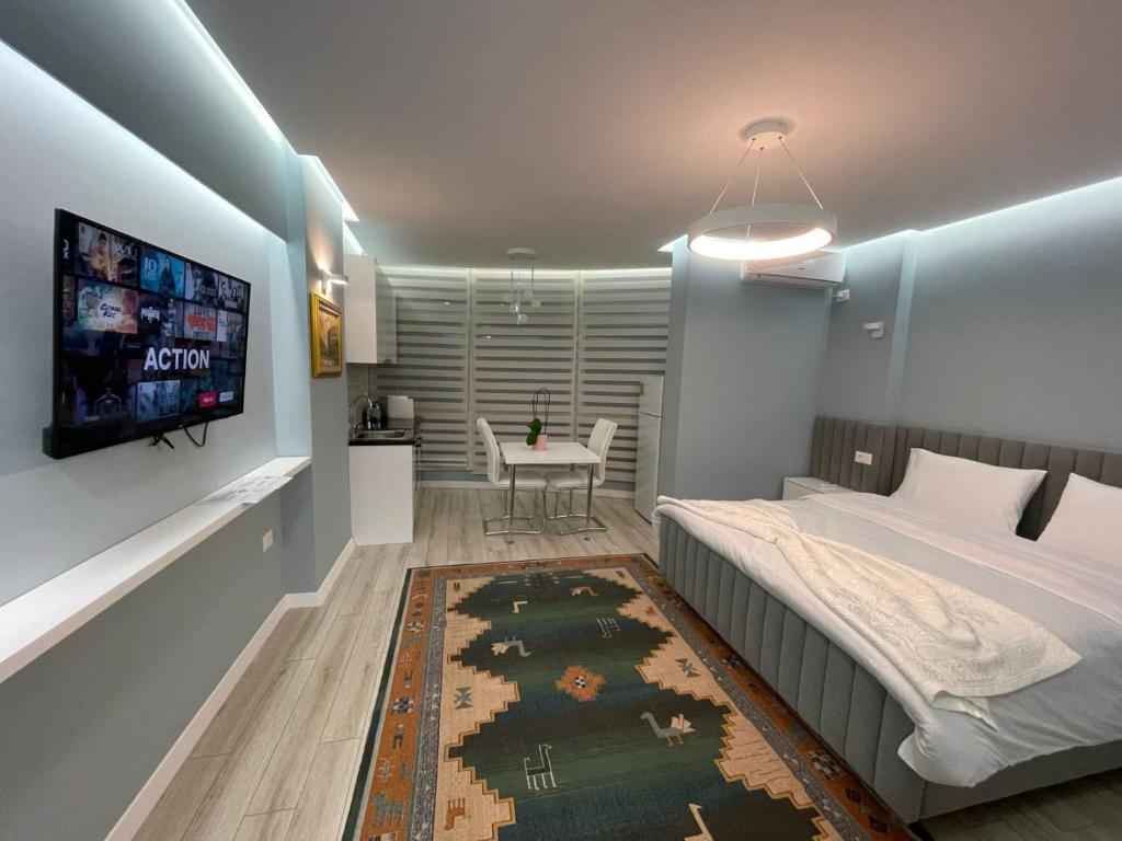 a bedroom with a bed and a tv on a wall at Comfort Apartment In City Center in Tirana