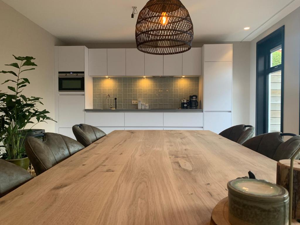 cocina grande con mesa de madera y sillas en 'T Hûske 66, en Burum