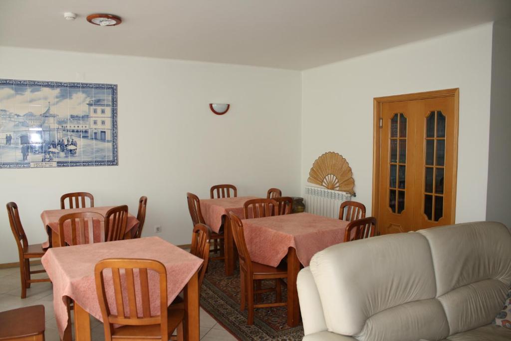 Residencial Stª Joana في أفيرو: غرفة معيشة مع طاولات وكراسي وأريكة