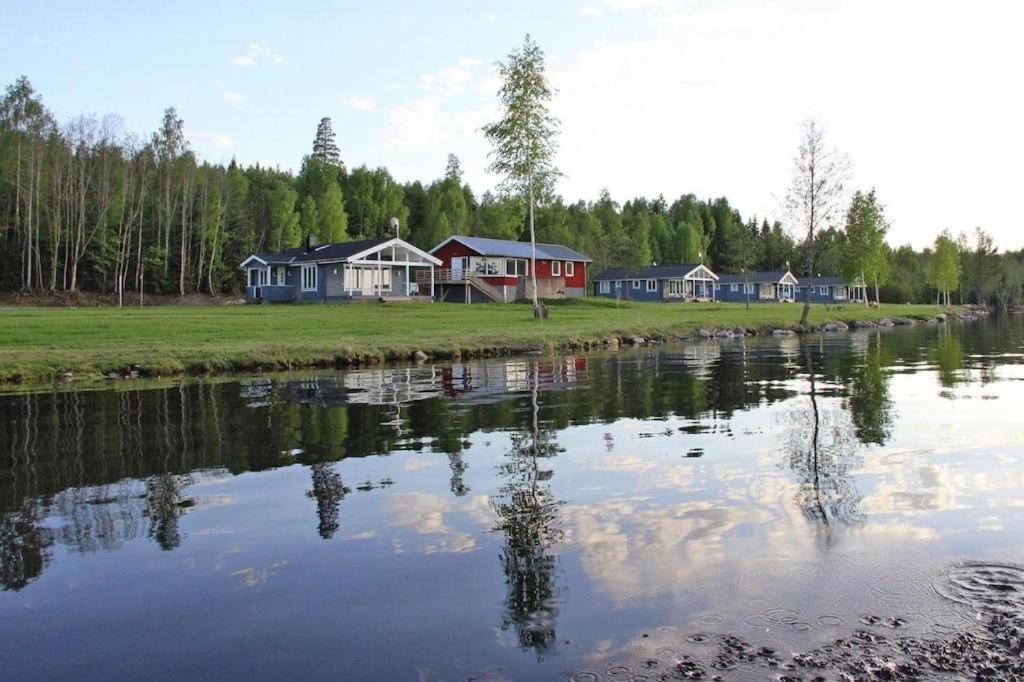 a group of houses next to a body of water at Lakeview Houses Sweden in Falun
