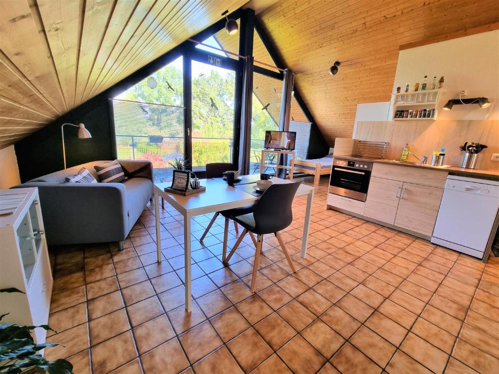 a kitchen and a living room with a table and a couch at Appartement Gartenblick in Glüsingerlohe