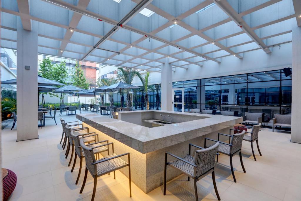 a large lobby with a bar with chairs and tables at Comfort Hotel Guarulhos Aeroporto in Guarulhos