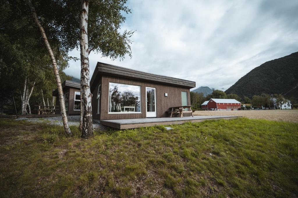 a small house with a large window on a field at Setnes Feriesenter in Veblungsnes