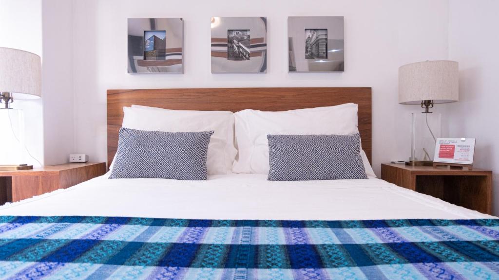 een slaapkamer met een wit bed met blauwe en witte kussens bij Habitación Privada para disfrutar en la Ciudad de México in Mexico-Stad