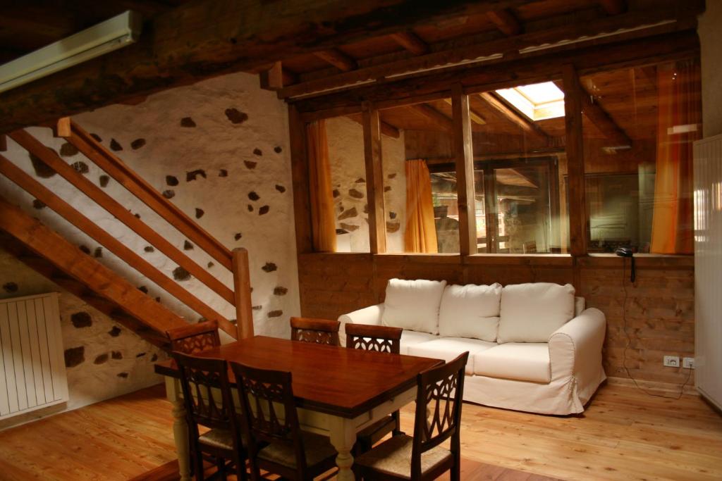 a living room with a white couch and a table at Casa del Vasaio in Tenno