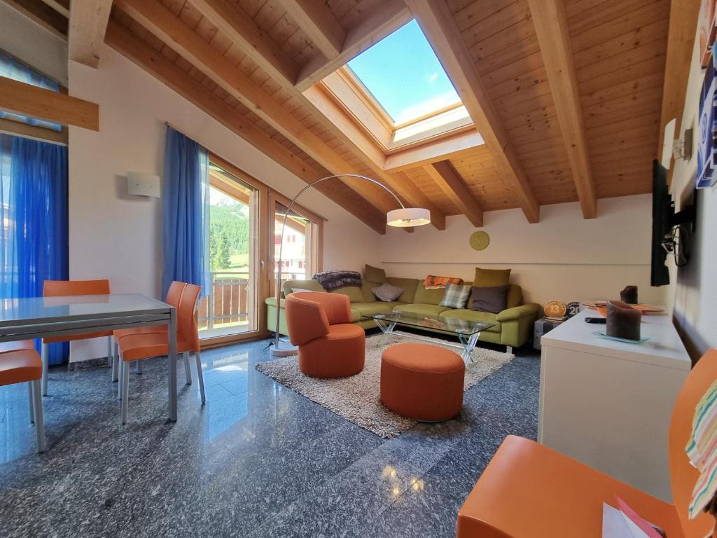 a living room with a vaulted ceiling with a skylight at Snowfun B Penthouse in Saas-Fee